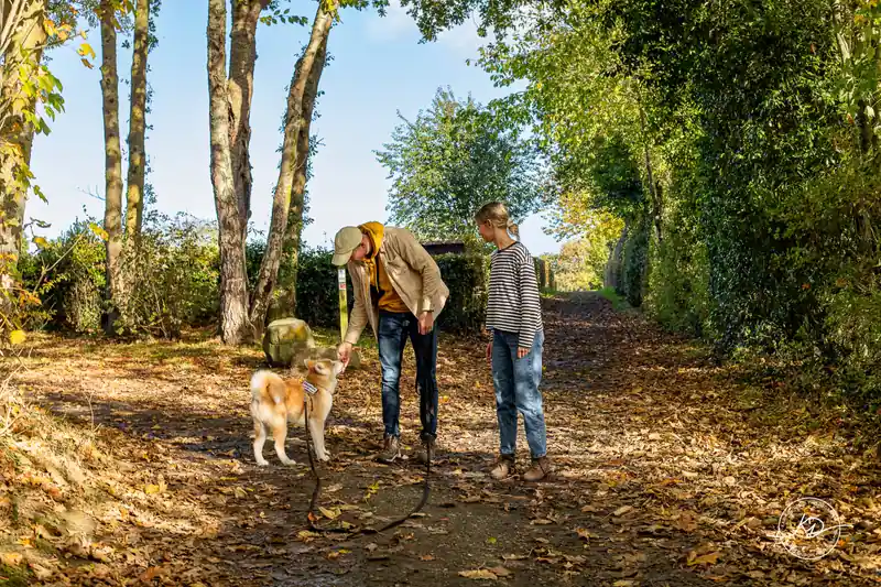 Cours d’éducation canine en extérieur : une éducatrice et une élève avec un jeune chien en laisse