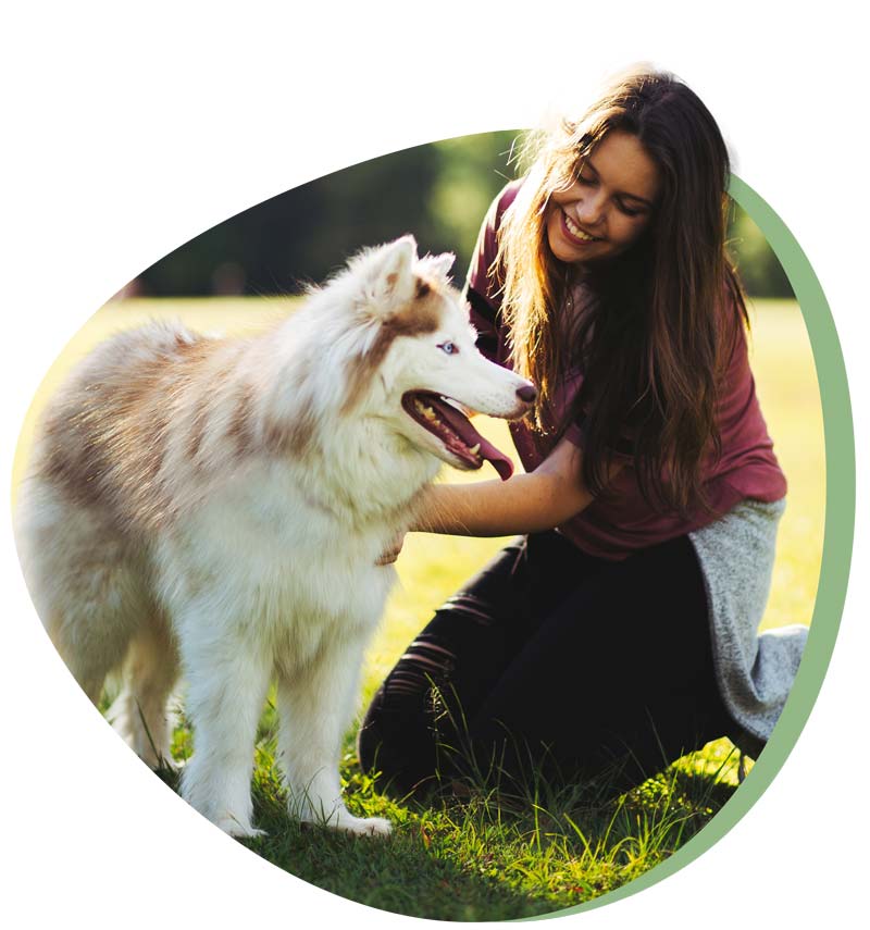une femme à genou avec un chien. cette photo illustre la formation de comportementaliste animalier  et d'éducateur canin.